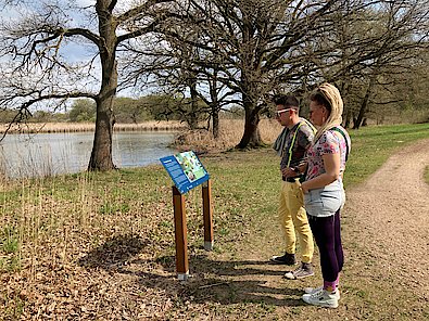 Infotafel am Kühnauer See mit interessierten Besuchern 